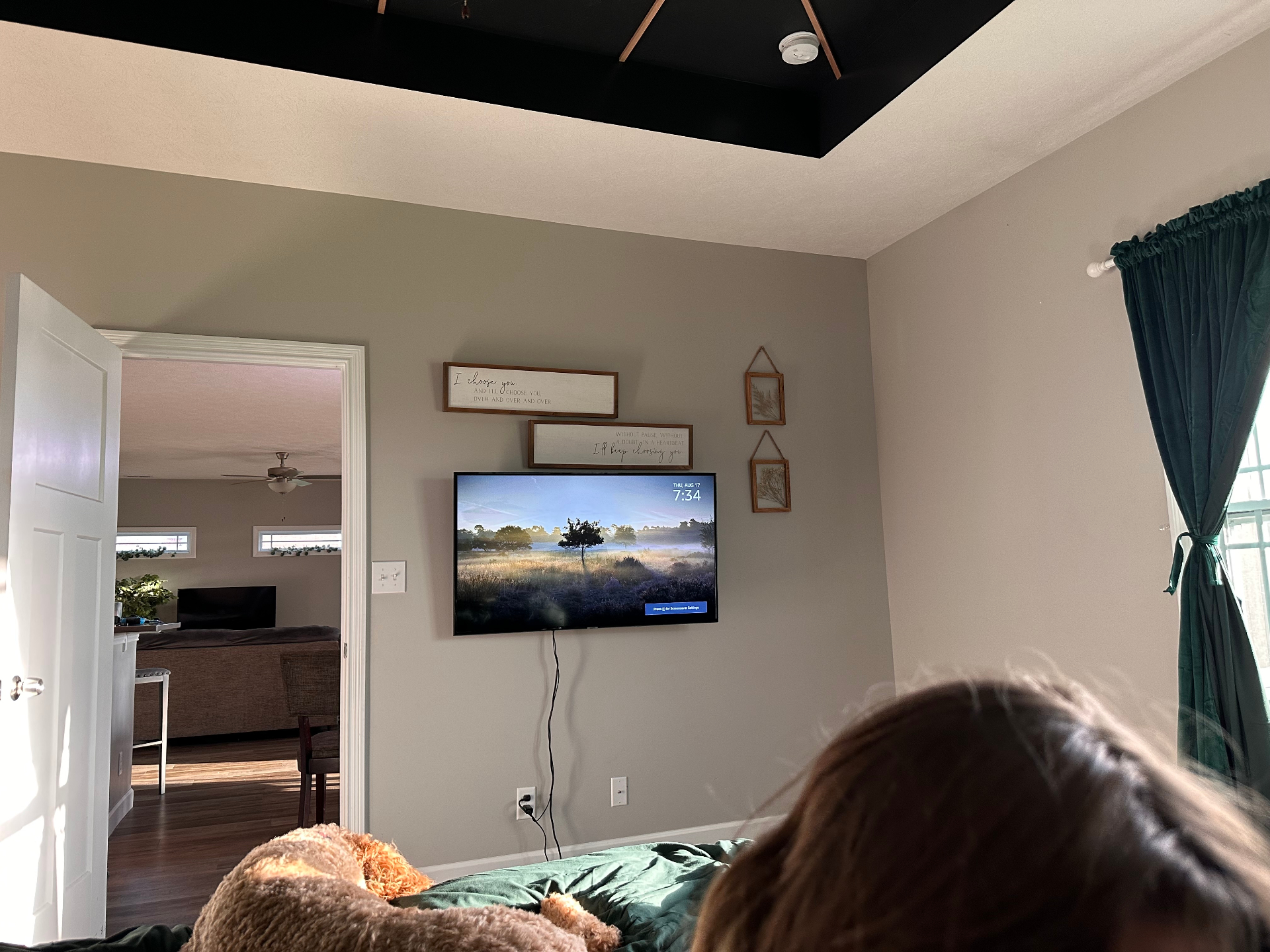 Master bedroom before — bare accent wall with mounted TV
